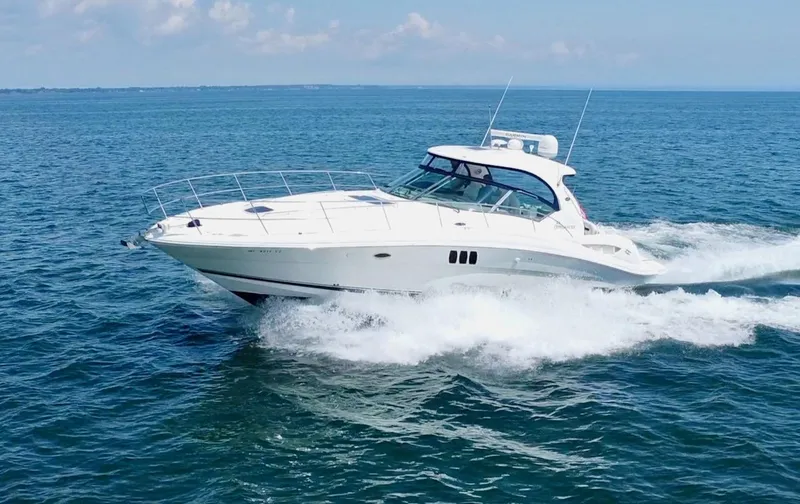 Slide: The Image of 2006 Sea Ray 44 Sundancer cruising on open water under clear skies. - 5