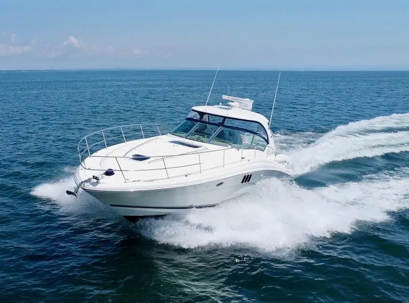 Slide: The Image of 2006 Sea Ray 44 Sundancer cruising on open water, creating waves. - 6