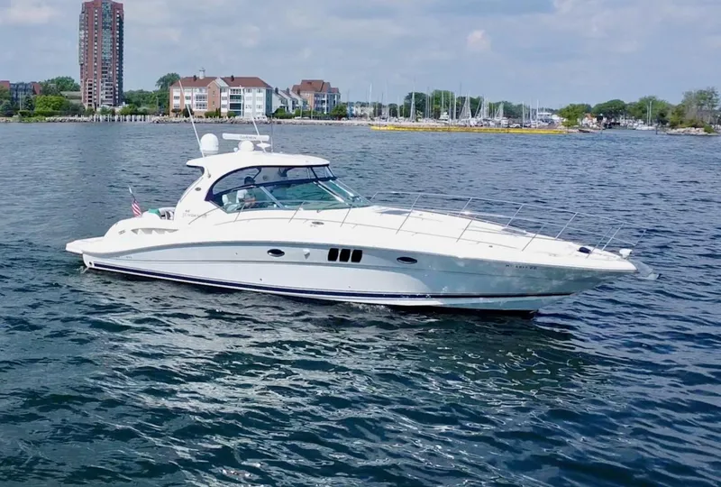 Slide: The Image of 2006 Sea Ray 44 Sundancer yacht cruising on a calm, scenic waterfront. - 9