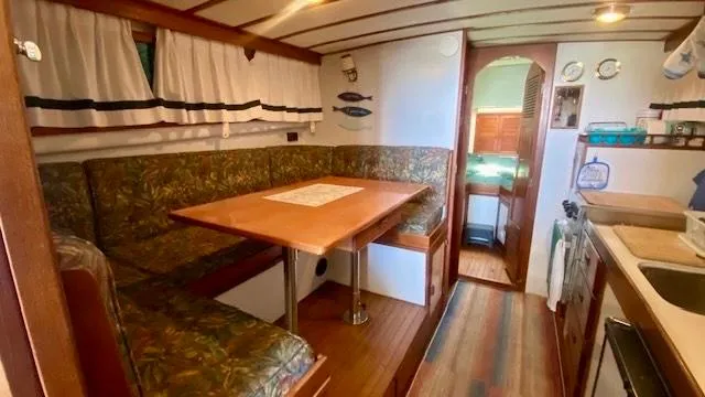 Slide: The Image of Cozy interior of 1987 Roughwater 37 boat with dining area and kitchen. - 11