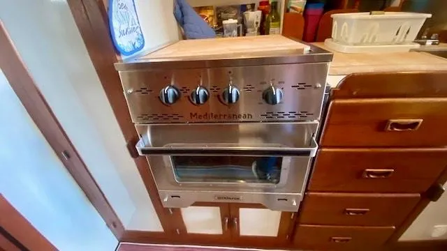 Slide: The Image of 1987 Roughwater 37 boat kitchen with Mediterranean stainless steel oven and wooden cabinetry. - 12