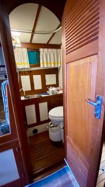 Slide: The Image of 1987 Roughwater 37 boat bathroom with wooden door, sink, and toilet. - 16