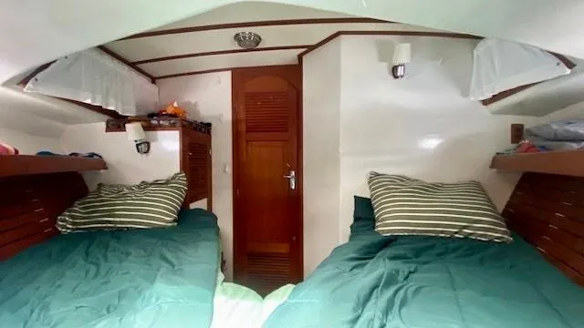 Slide: The Image of Interior of 1987 Roughwater 37 boat cabin with twin beds and wooden accents. - 17