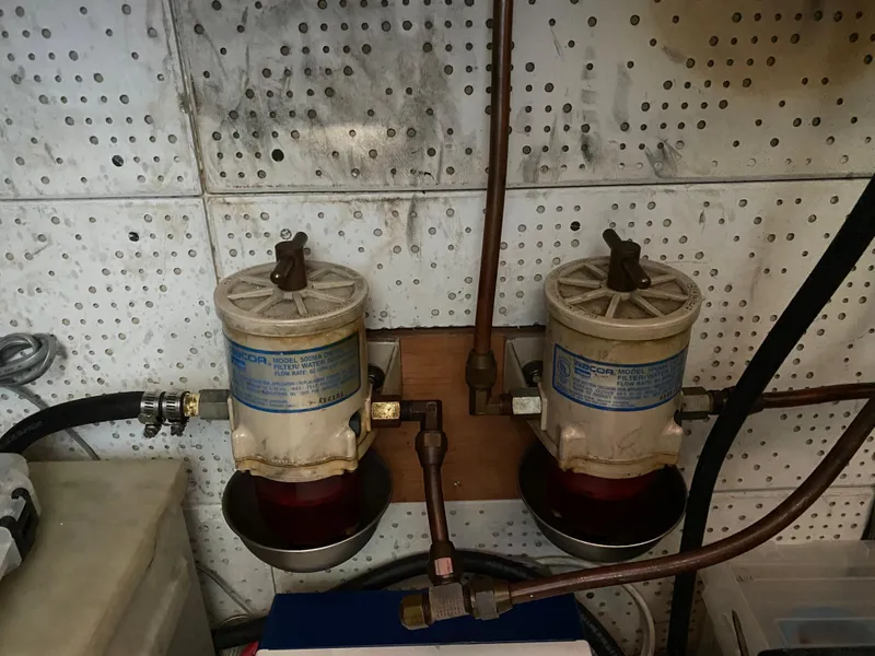 Slide: The Image of Dual fuel filters in a 1987 Roughwater 37 engine room, mounted on a perforated wall. - 24