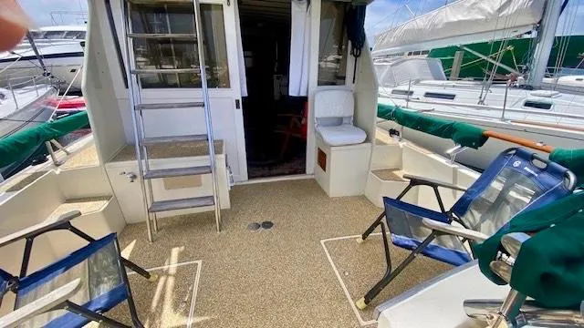 Slide: The Image of 1987 Roughwater 37 boat deck with seating, ladder, and open cabin entrance. - 6