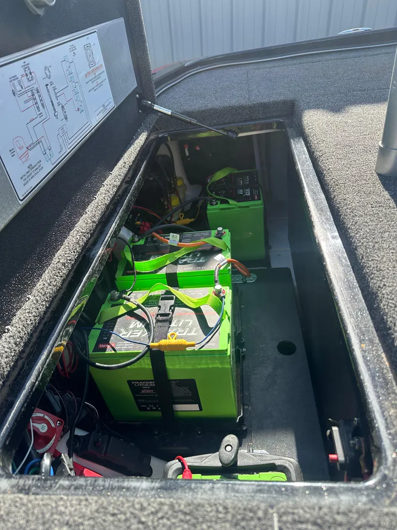 Slide: The Image of 2024 Nitro Z21XL boat battery compartment with green batteries and wiring. - 12