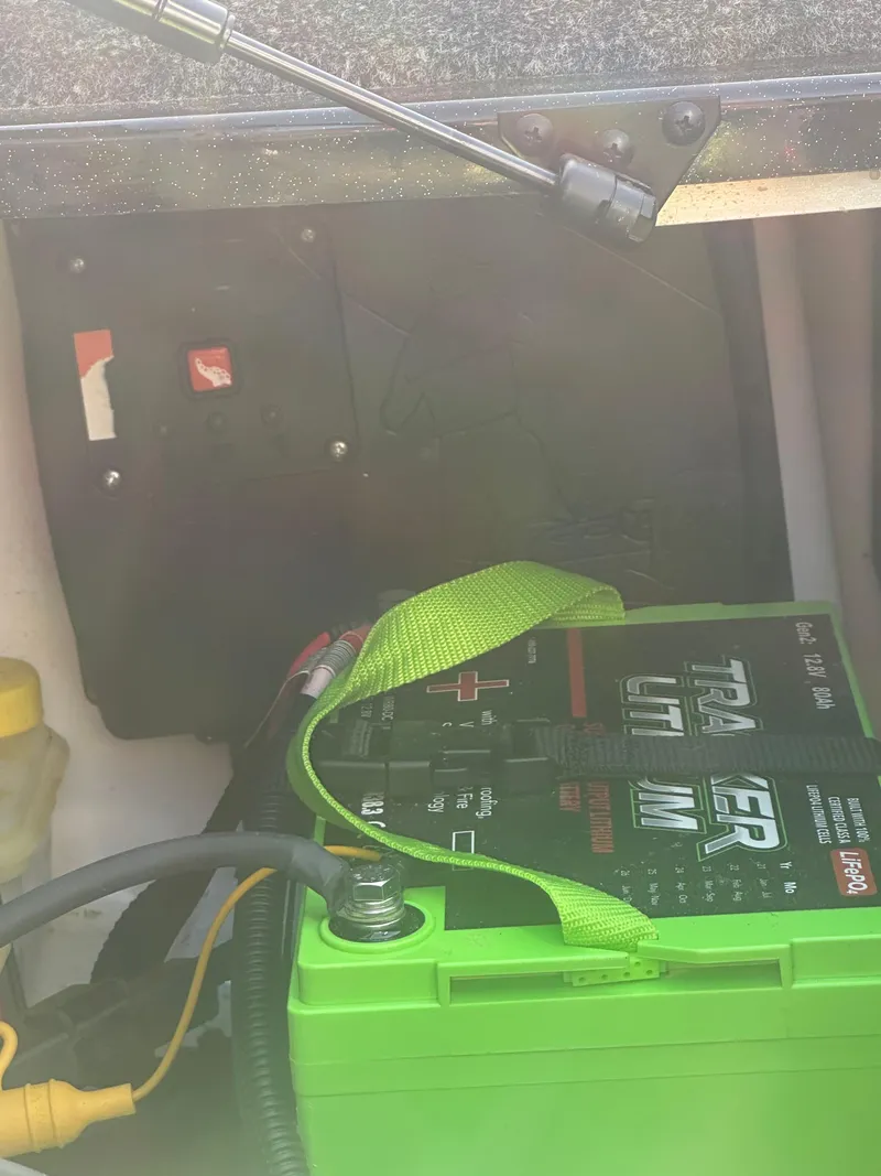 Slide: The Image of 2024 Nitro Z21XL boat battery compartment with green battery and wiring. - 13