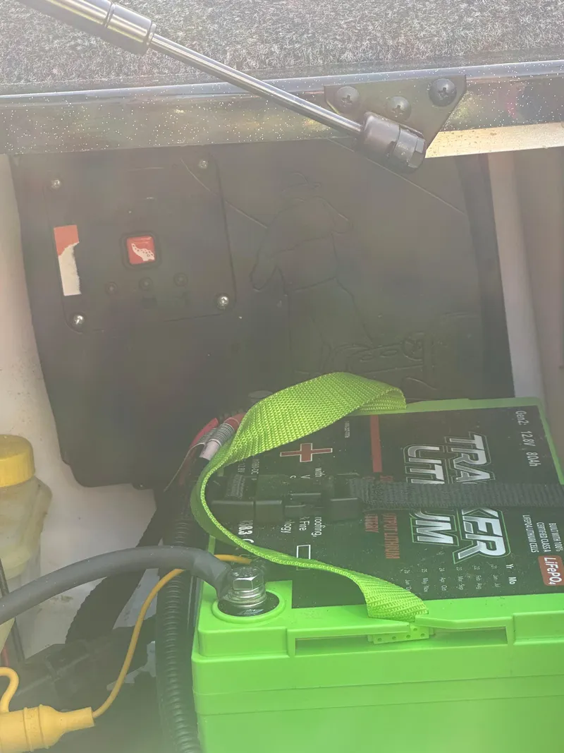 Slide: The Image of 2024 Nitro Z21XL boat battery compartment with green battery and wiring. - 14