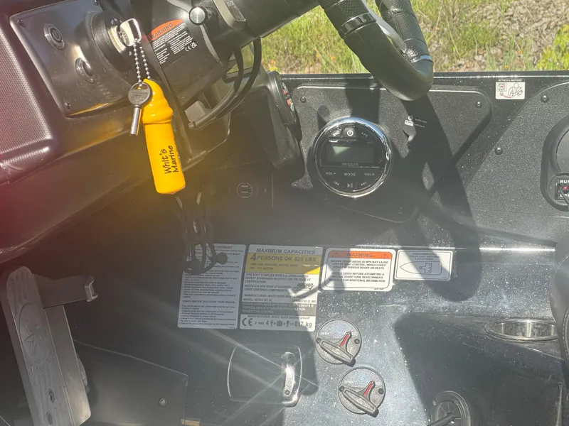 Slide: The Image of 2024 Nitro Z21XL boat dashboard with steering wheel, controls, and safety key. - 17