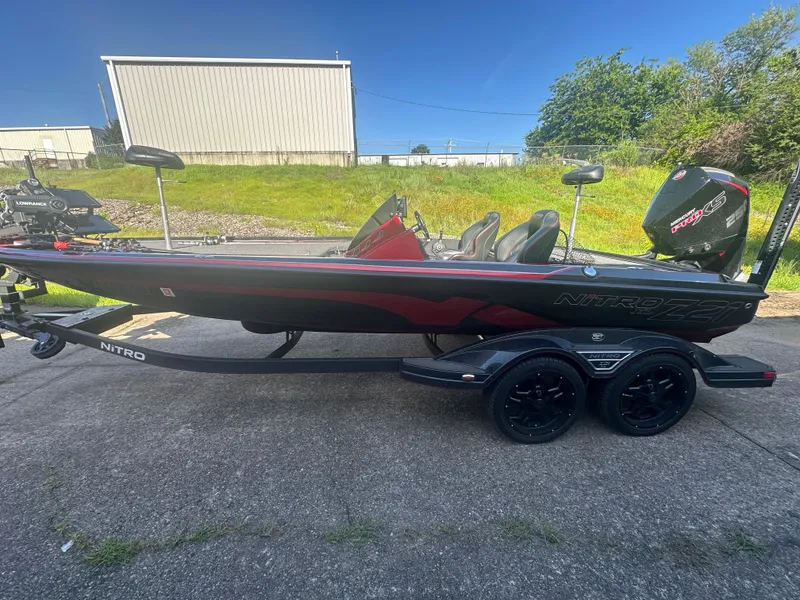 Slide: The Image of 2024 Nitro Z21XL boat on trailer, black and red design, parked outdoors. - 3
