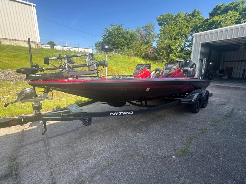 Slide: The Image of 2024 Nitro Z21XL boat on trailer, parked outside a garage, sunny day. - 4