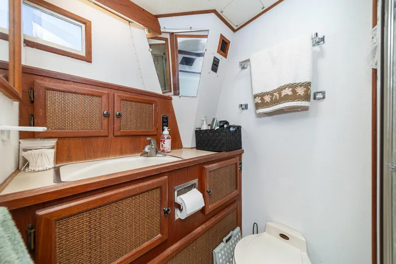 Slide: The Image of 1982 Viking 44 Motor Yacht bathroom with wooden cabinets and modern amenities. - 11