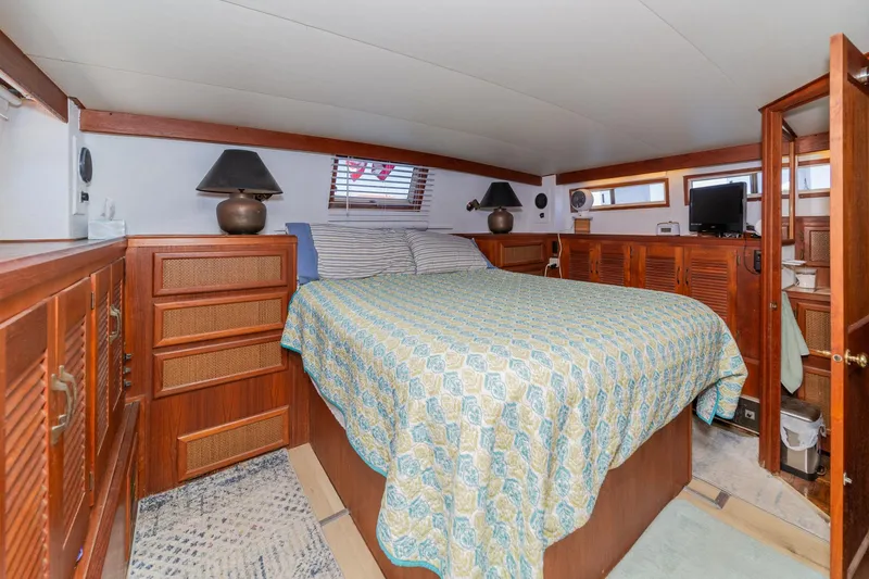 Slide: The Image of 1982 Viking 44 Motor Yacht bedroom with wood paneling, cozy bed, and nautical decor. - 14