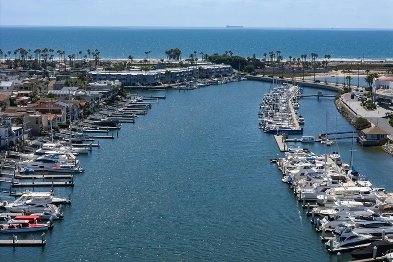 Slide: The Image of Aerial view of a marina with yachts, including a 1982 Viking 44 Motor Yacht, near the ocean. - 21