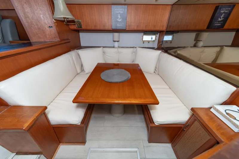 Slide: The Image of 1982 Viking 44 Motor Yacht interior with wooden dining table and cushioned seating. - 22