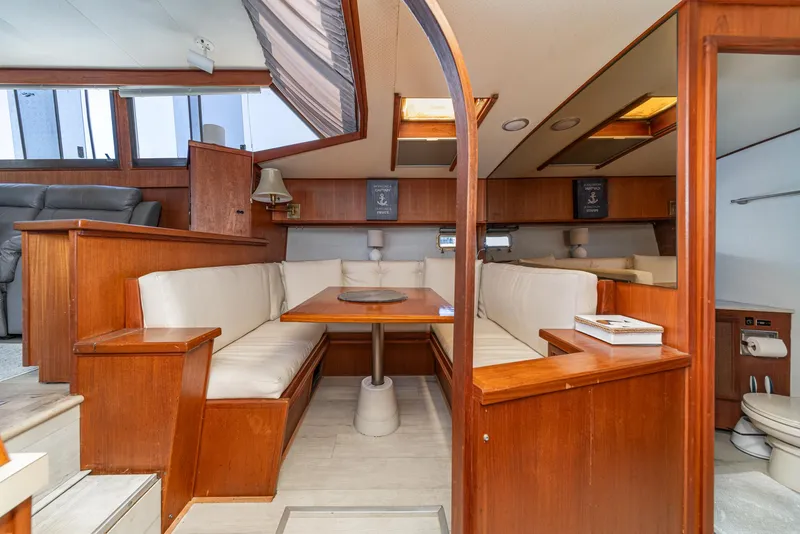 Slide: The Image of 1982 Viking 44 Motor Yacht interior with wood finish and cozy seating area. - 23