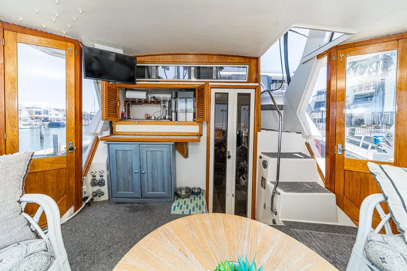 Slide: The Image of 1982 Viking 44 Motor Yacht interior with wood accents, TV, and stairs leading to upper deck. - 29