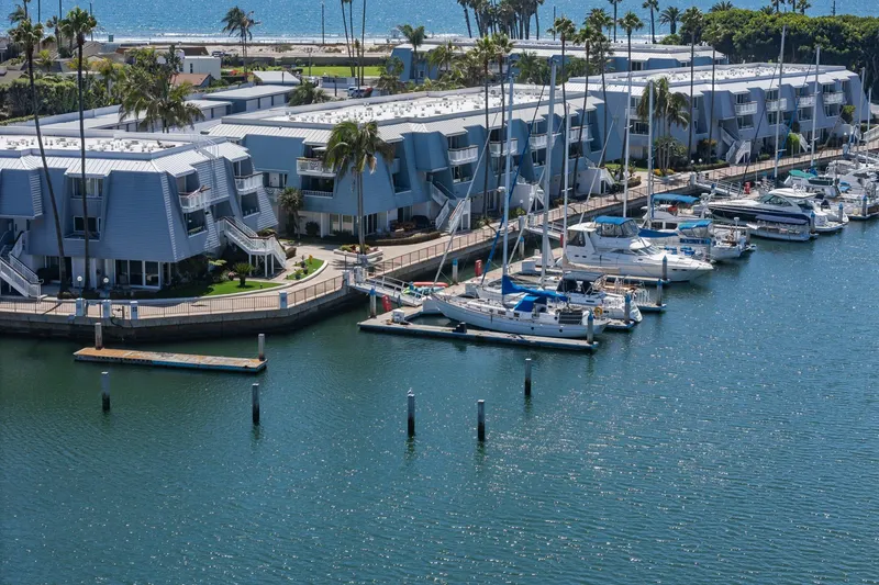 Slide: The Image of Marina with yachts, including a 1982 Viking 44 Motor Yacht, near modern waterfront buildings. - 30