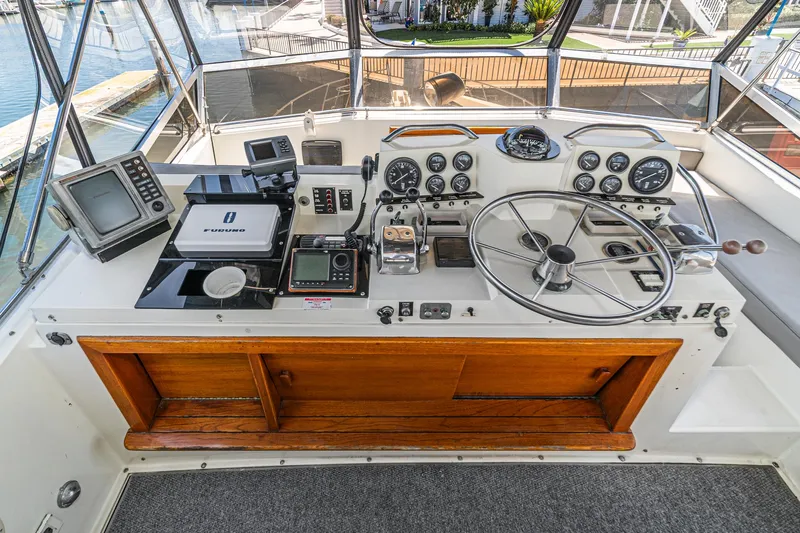 Slide: The Image of 1982 Viking 44 Motor Yacht helm with navigation equipment and steering wheel. - 34
