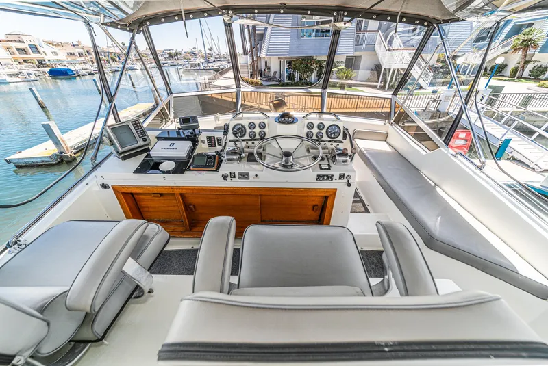 Slide: The Image of 1982 Viking 44 Motor Yacht helm with modern navigation equipment and waterfront view. - 35