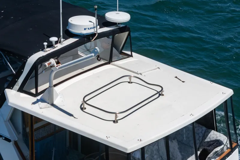 Slide: The Image of 1982 Viking 44 Motor Yacht roof with radar equipment, cruising on blue water. - 36