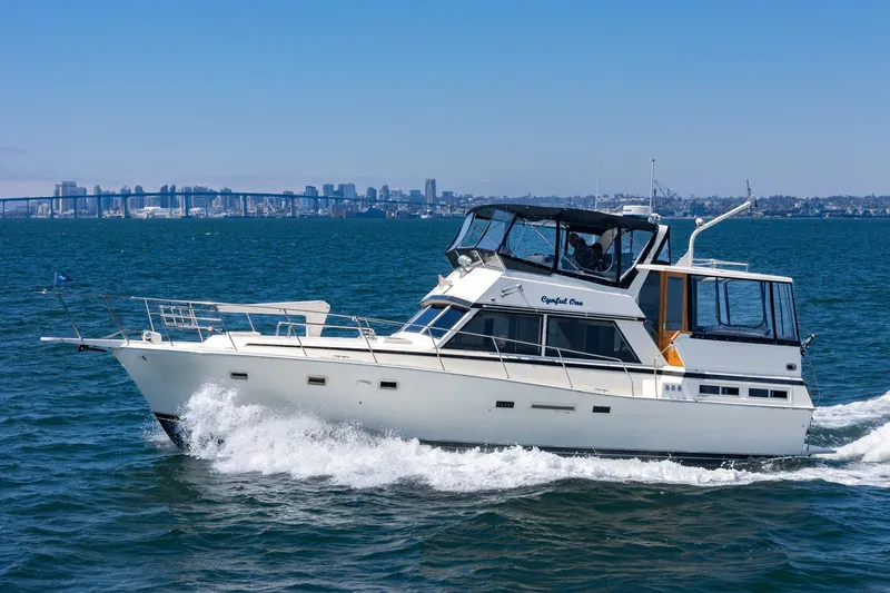 Slide: The Image of 1982 Viking 44 Motor Yacht cruising on open water with city skyline in background. - 39