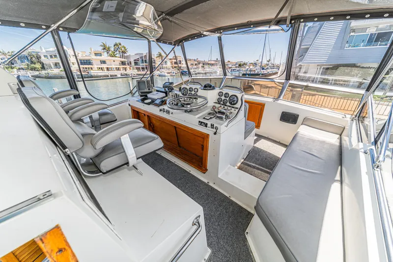 Slide: The Image of 1982 Viking 44 Motor Yacht cockpit with helm, seating, and marina view. - 7
