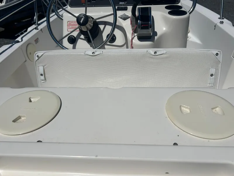 Slide: The Image of 2004 Boston Whaler 190 Nantucket boat interior with steering wheel and storage compartments. - 15