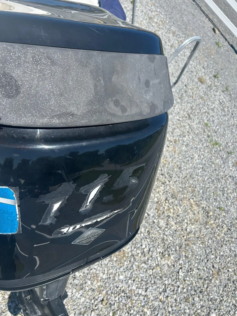 Slide: The Image of Outboard motor of a 2004 Boston Whaler 190 Nantucket on gravel surface. - 25