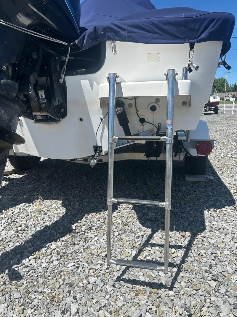 Slide: The Image of 2004 Boston Whaler 190 Nantucket boat with ladder on gravel surface. - 26