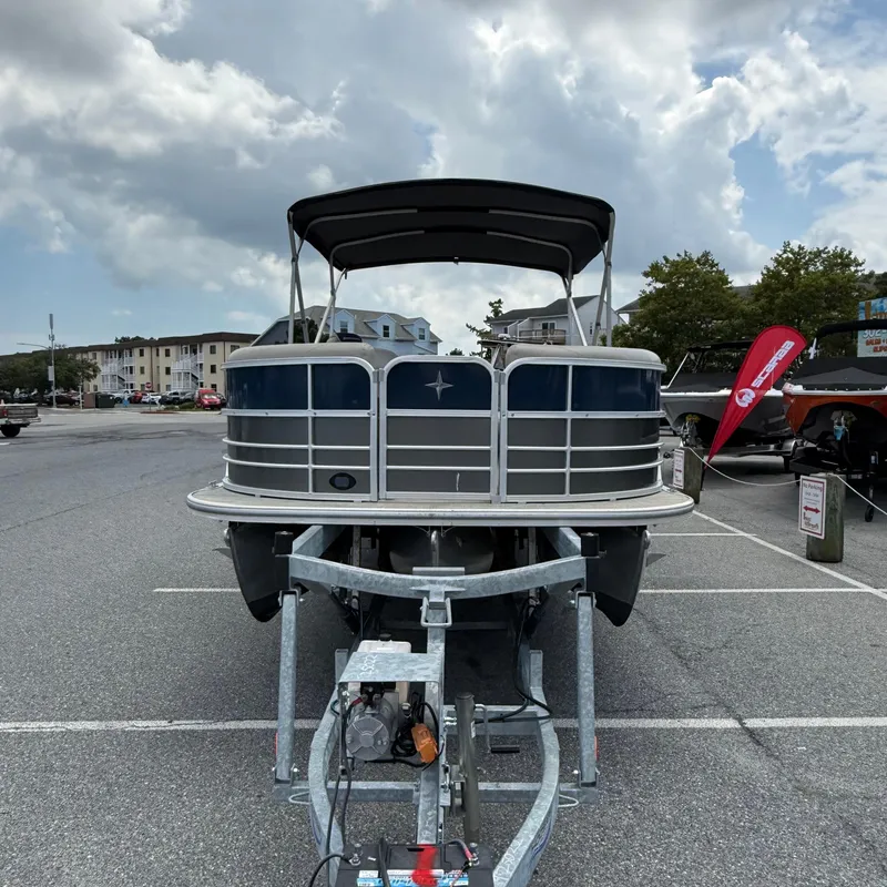 Slide: The Image of 2022 Berkshire 24RFC LE 2.75 pontoon boat on trailer, parked outdoors under cloudy sky. - 3