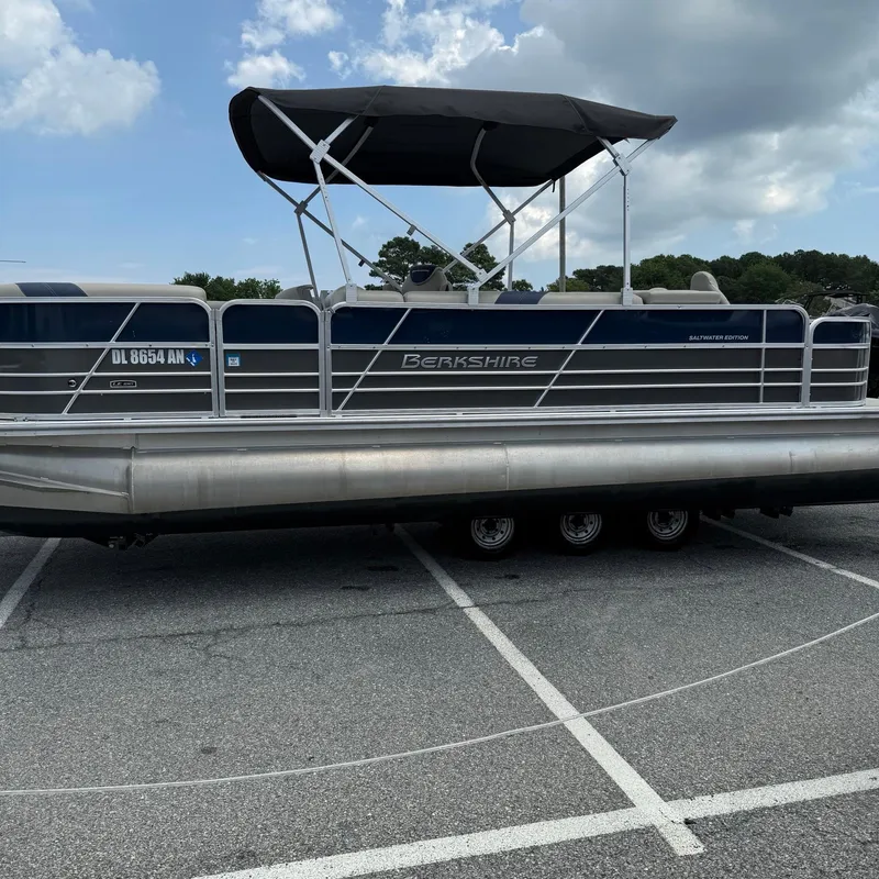 Slide: The Image of 2022 Berkshire 24RFC LE 2.75 pontoon boat parked in a lot under cloudy sky. - 4