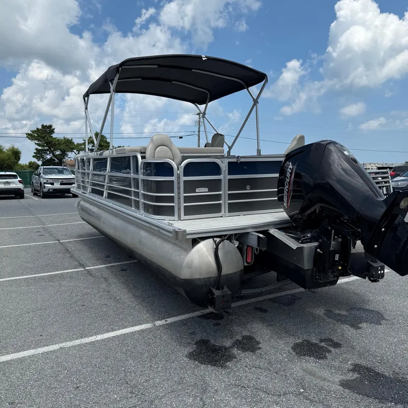 Slide: The Image of 2022 Berkshire 24RFC LE 2.75 pontoon boat parked, featuring a Mercury outboard motor. - 5