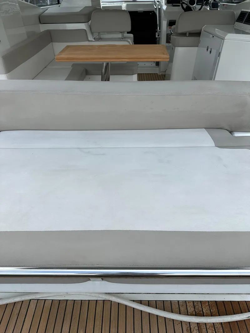 Slide: The Image of 2016 Jeanneau Leader 36 boat interior with seating and wooden table. - 17