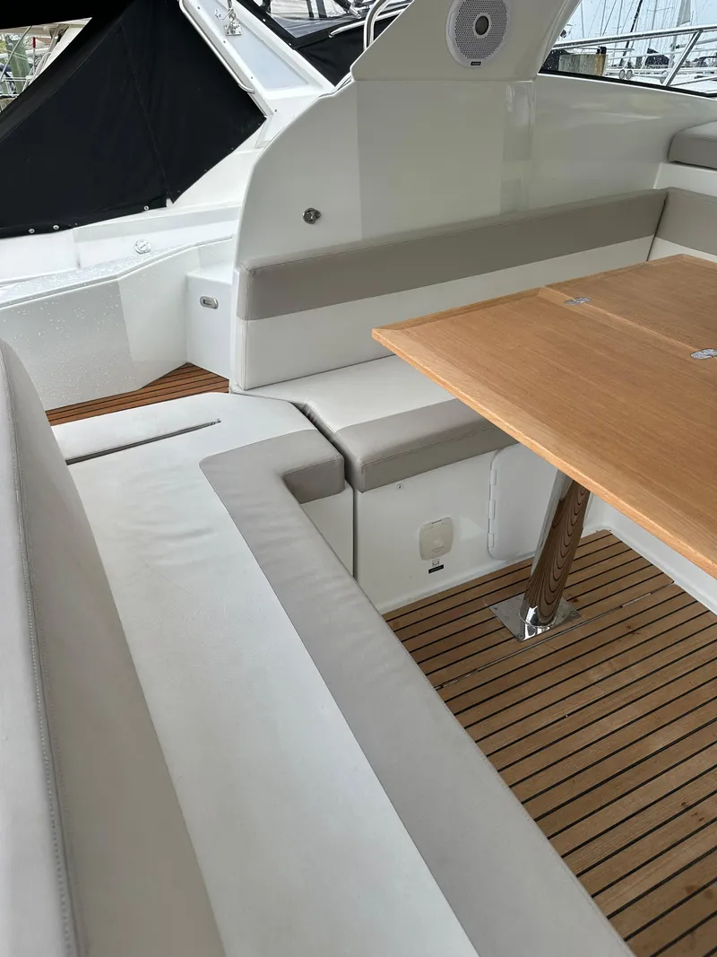 Slide: The Image of 2016 Jeanneau Leader 36 boat interior with cushioned seating and wooden table. - 19