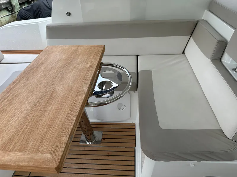 Slide: The Image of Jeanneau Leader 36 2016 boat interior with wooden table and cushioned seating. - 20
