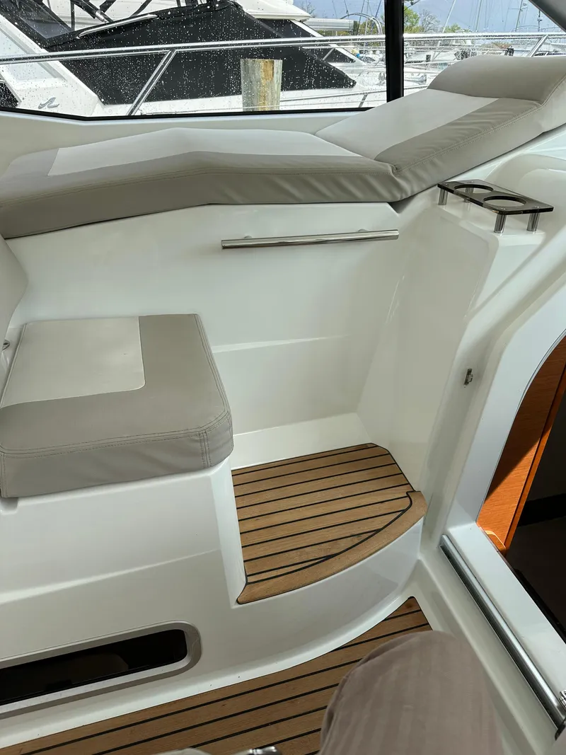 Slide: The Image of 2016 Jeanneau Leader 36 interior seating area with wooden steps. - 28