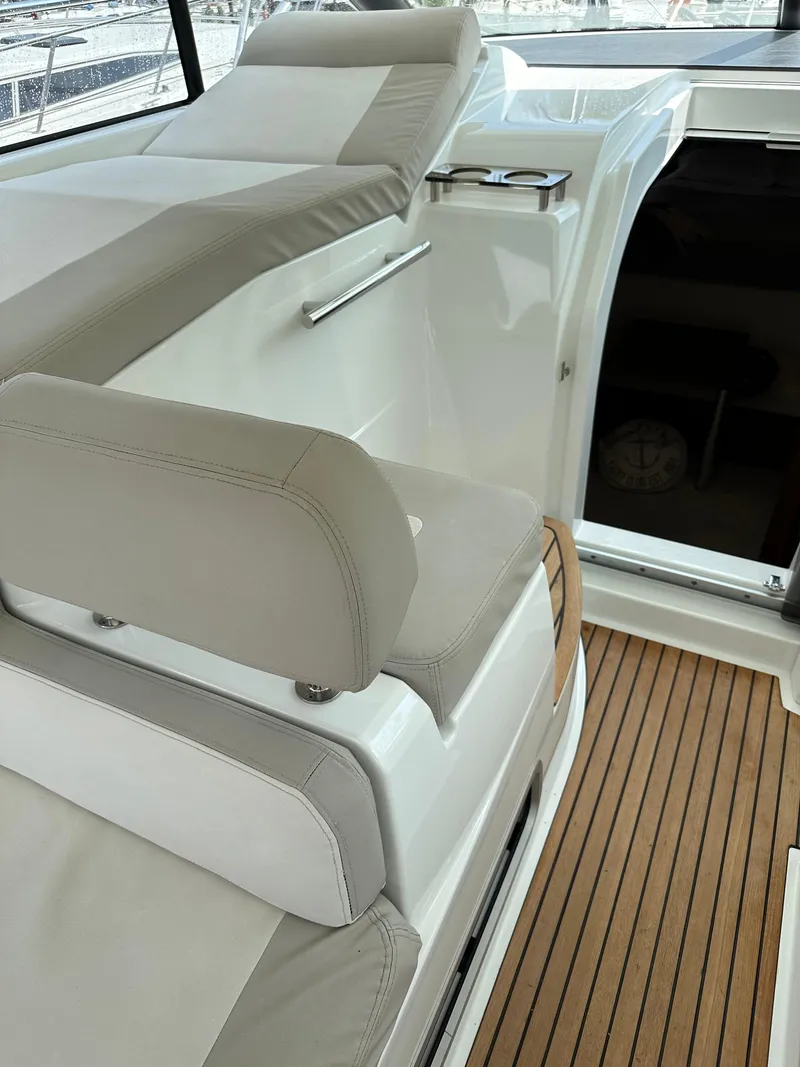 Slide: The Image of 2016 Jeanneau Leader 36 boat interior with cushioned seating and wooden flooring. - 29