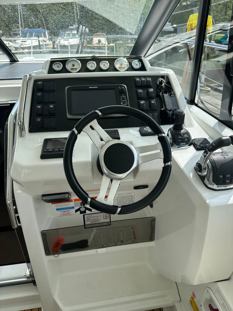 Slide: The Image of 2016 Jeanneau Leader 36 helm station with steering wheel and navigation controls. - 33
