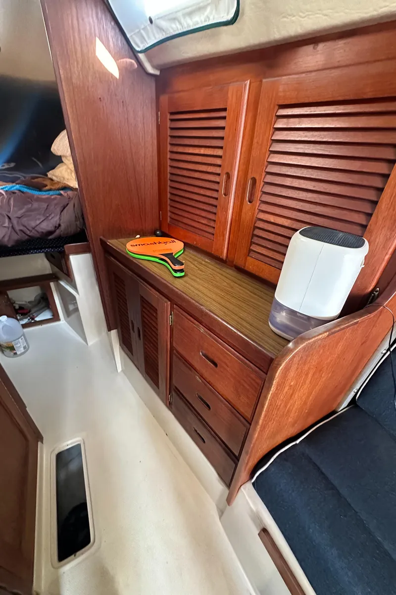 Slide: The Image of Interior of 1984 Catalina 38 sailboat with wooden cabinets and seating area. - 12
