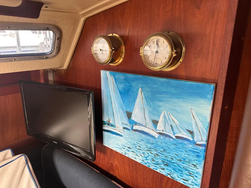 Slide: The Image of Interior of a 1984 Catalina 38 sailboat with nautical decor and a mounted TV. - 17