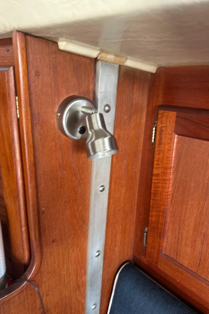 Slide: The Image of Wooden interior of a 1984 Catalina 38 sailboat with a metal light fixture. - 18