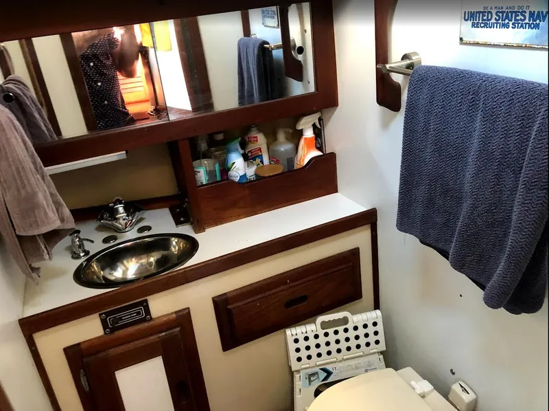 Slide: The Image of 1984 Catalina 38 yacht bathroom with sink, mirror, and storage shelves. - 19
