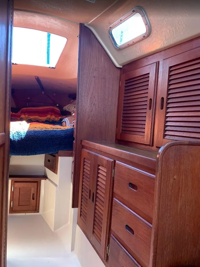 Slide: The Image of 1984 Catalina 38 sailboat interior with wooden cabinets and cozy sleeping area. - 22