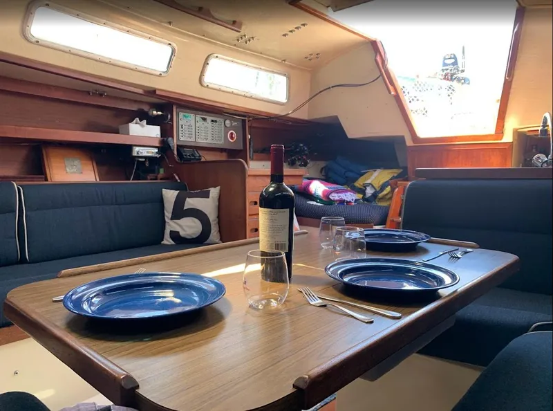 Slide: The Image of Interior of 1984 Catalina 38 sailboat with dining setup and wine bottle. - 25