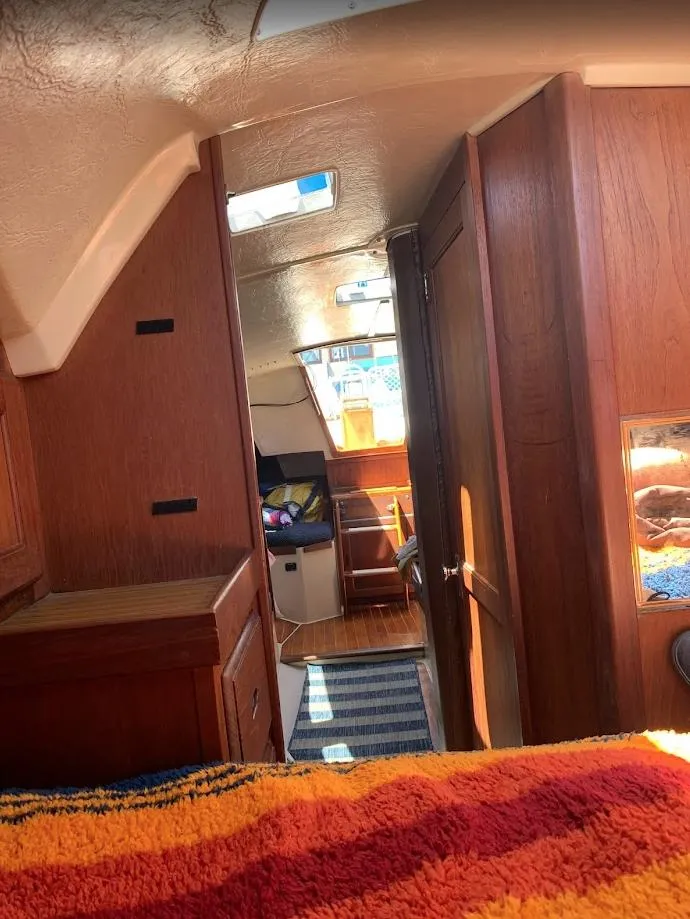 Slide: The Image of Interior of a 1984 Catalina 38 sailboat with wooden cabinetry and cozy furnishings. - 27