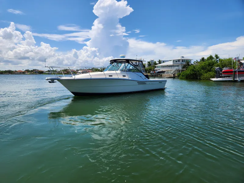 Slide: The Image of 2003 Pursuit 3000 Express boat on calm water under a clear blue sky. - 1