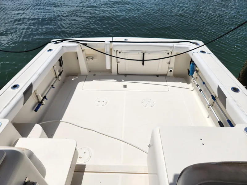 Slide: The Image of 2003 Pursuit 3000 Express boat deck, spacious and clean, docked by the water. - 12