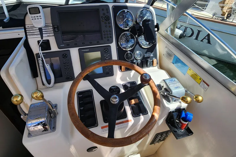 Slide: The Image of Control panel of a 2003 Pursuit 3000 Express boat with steering wheel and gauges. - 16