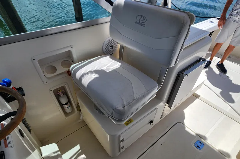 Slide: The Image of 2003 Pursuit 3000 Express boat interior with helm seat and storage compartments. - 18